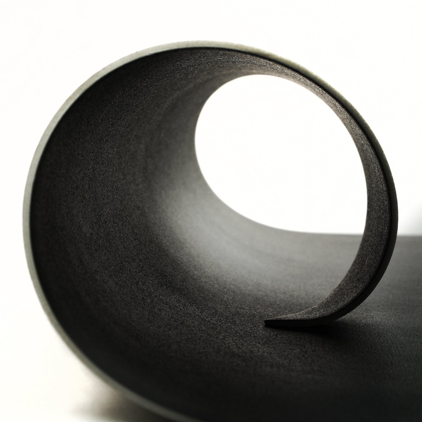 Textured black curved material showcasing a smooth, modern design for versatile use.