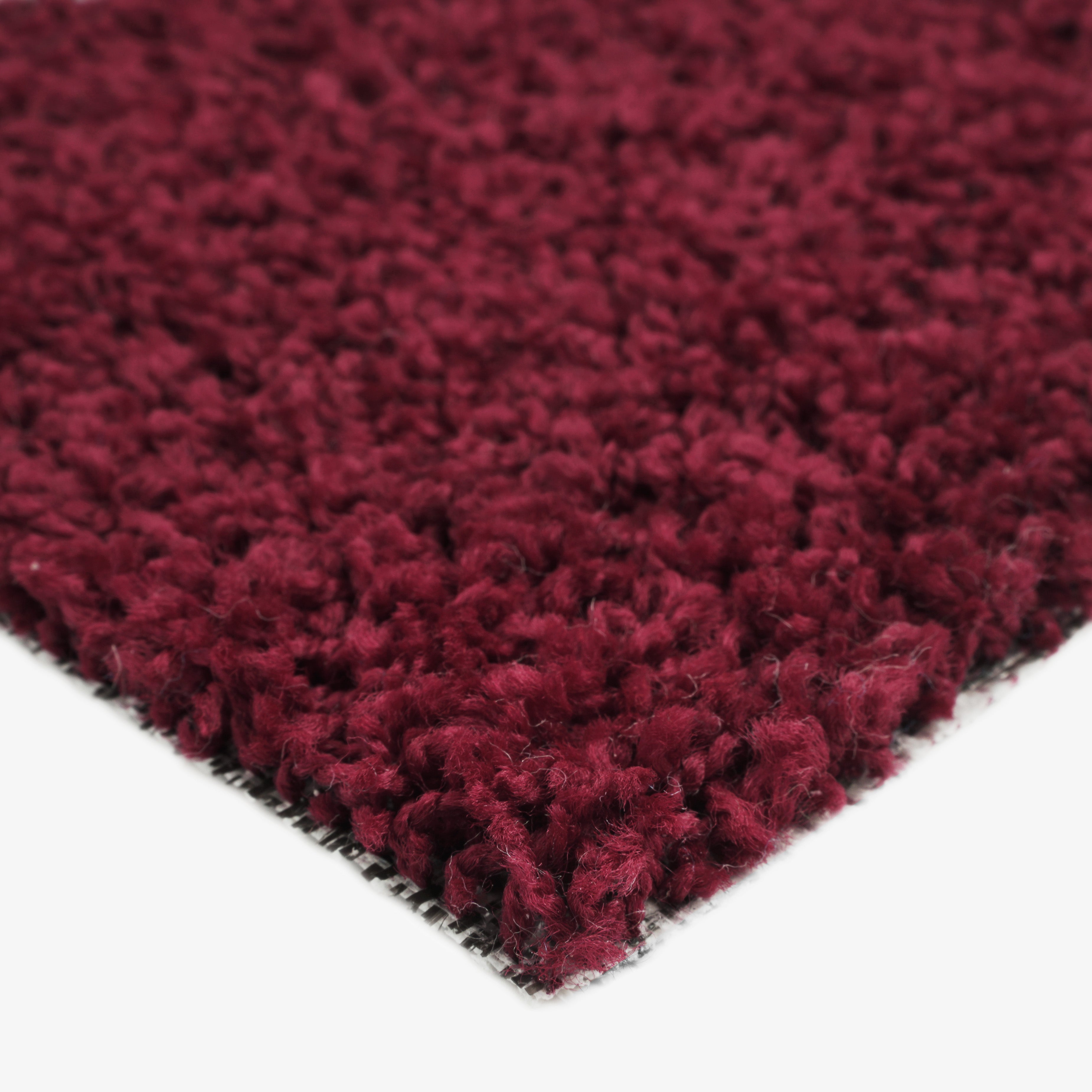 Soft burgundy shag rug made from plush fibers, perfect for adding warmth to any room.