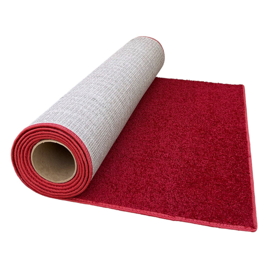 Rolled red plush carpet with gray backing, ideal for adding warmth and comfort to any space.