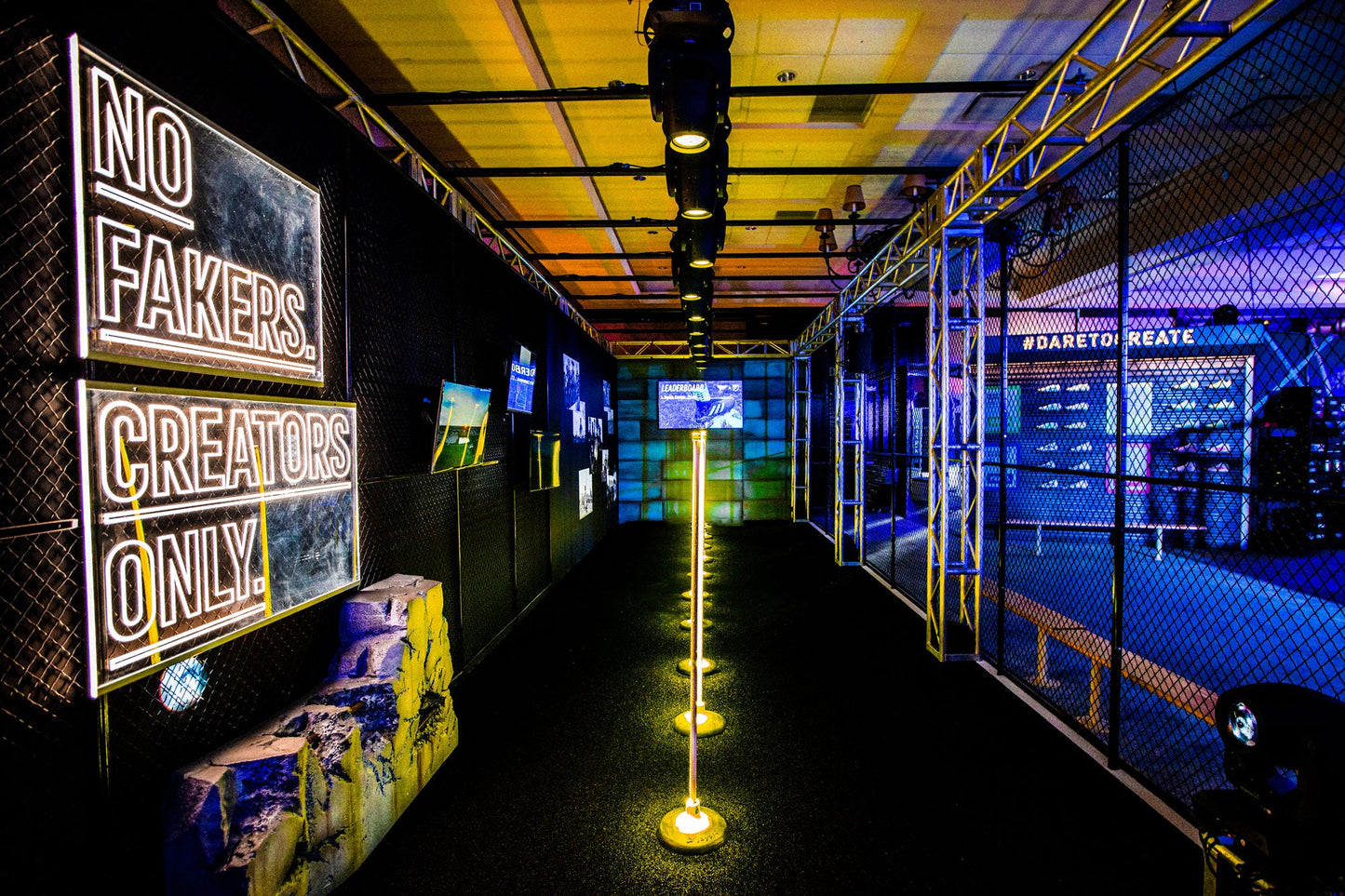Vibrant event space featuring neon signs, creative displays, and dramatic lighting for artists and creators.