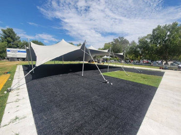 Large beige party tent set up on grass, ideal for outdoor events and gatherings.