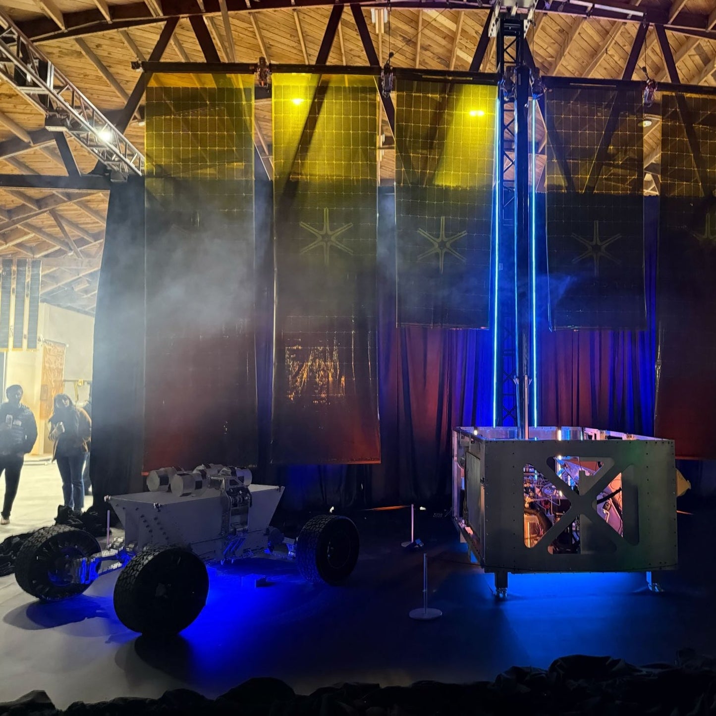 Innovative rover model with black wheels, showcasing advanced design and technology in an exhibition space.