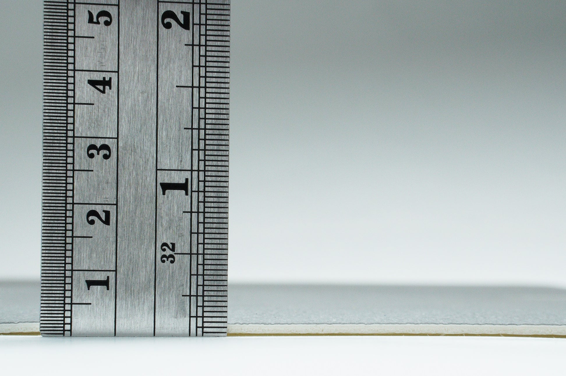 Ruler measuring a textured gray product, showcasing its size and material details for accurate selection.