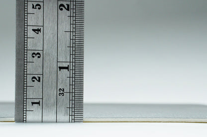 Ruler measuring a textured gray product, showcasing its size and material details for accurate selection.