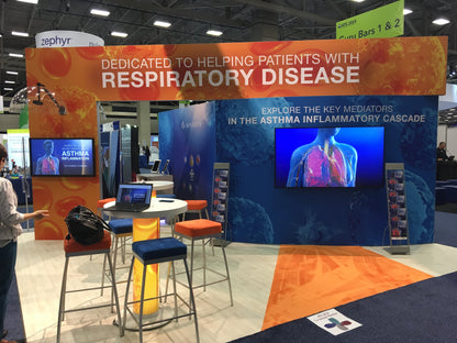Interactive booth for respiratory disease with vibrant colors, seating, and educational screens on asthma.