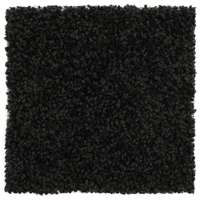 Black plush area rug, soft synthetic material, perfect for modern home decor and cozy ambiance.