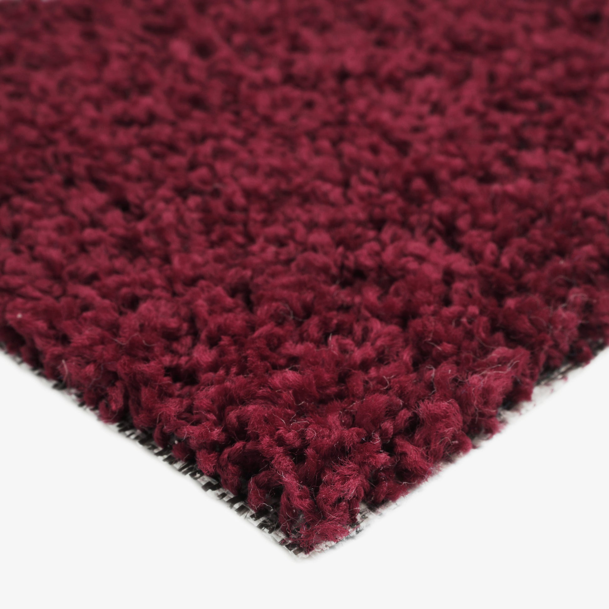 Soft burgundy shag rug made from plush fibers, perfect for adding warmth to any room.