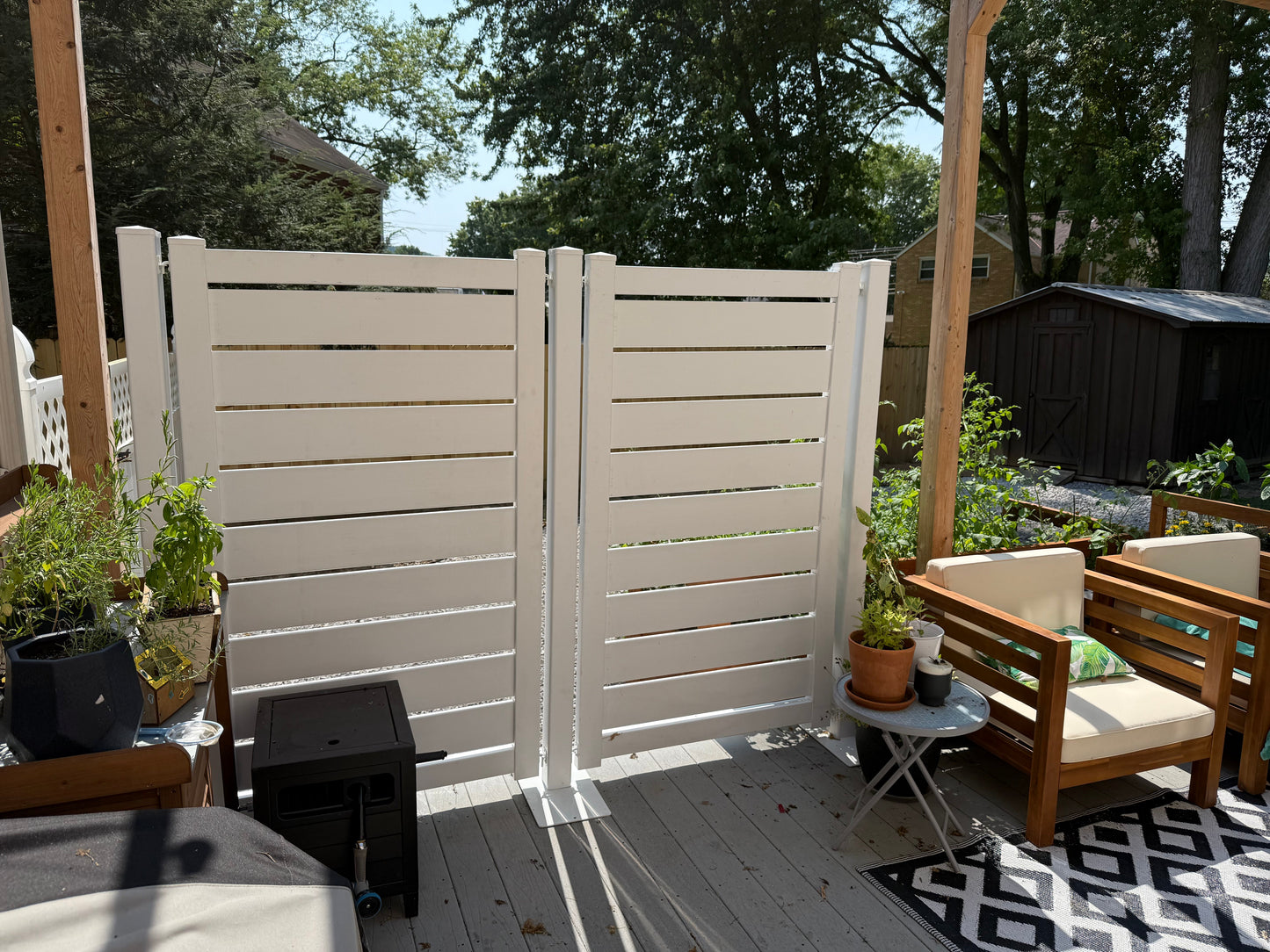 Modern white wooden privacy fence with slats, enhancing outdoor space and style.
