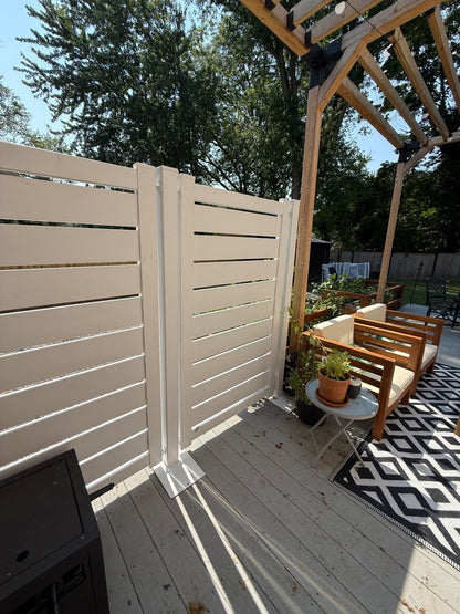 White slatted wooden privacy fence on a deck, enhancing outdoor space with stylish separation.