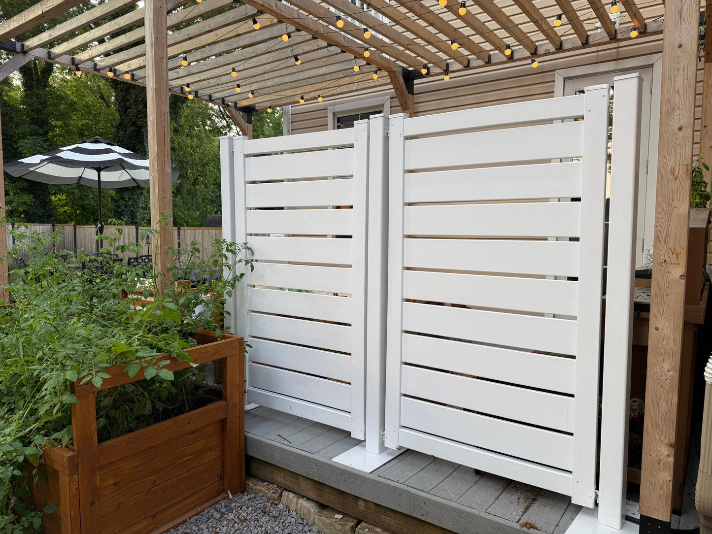 Stylish white wooden privacy panels, slatted design, perfect for outdoor gardens and patio spaces.