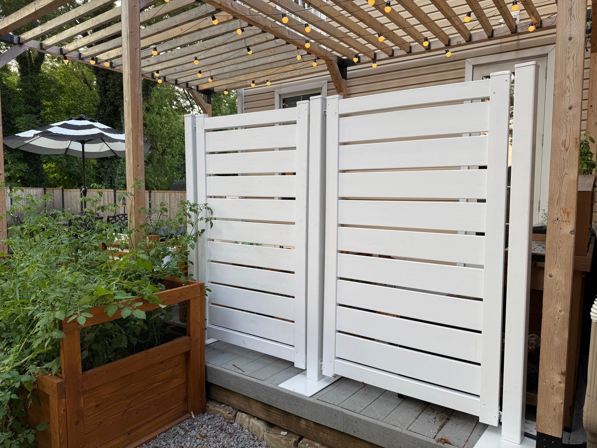 Stylish white wooden privacy panels, slatted design, perfect for outdoor gardens and patio spaces.