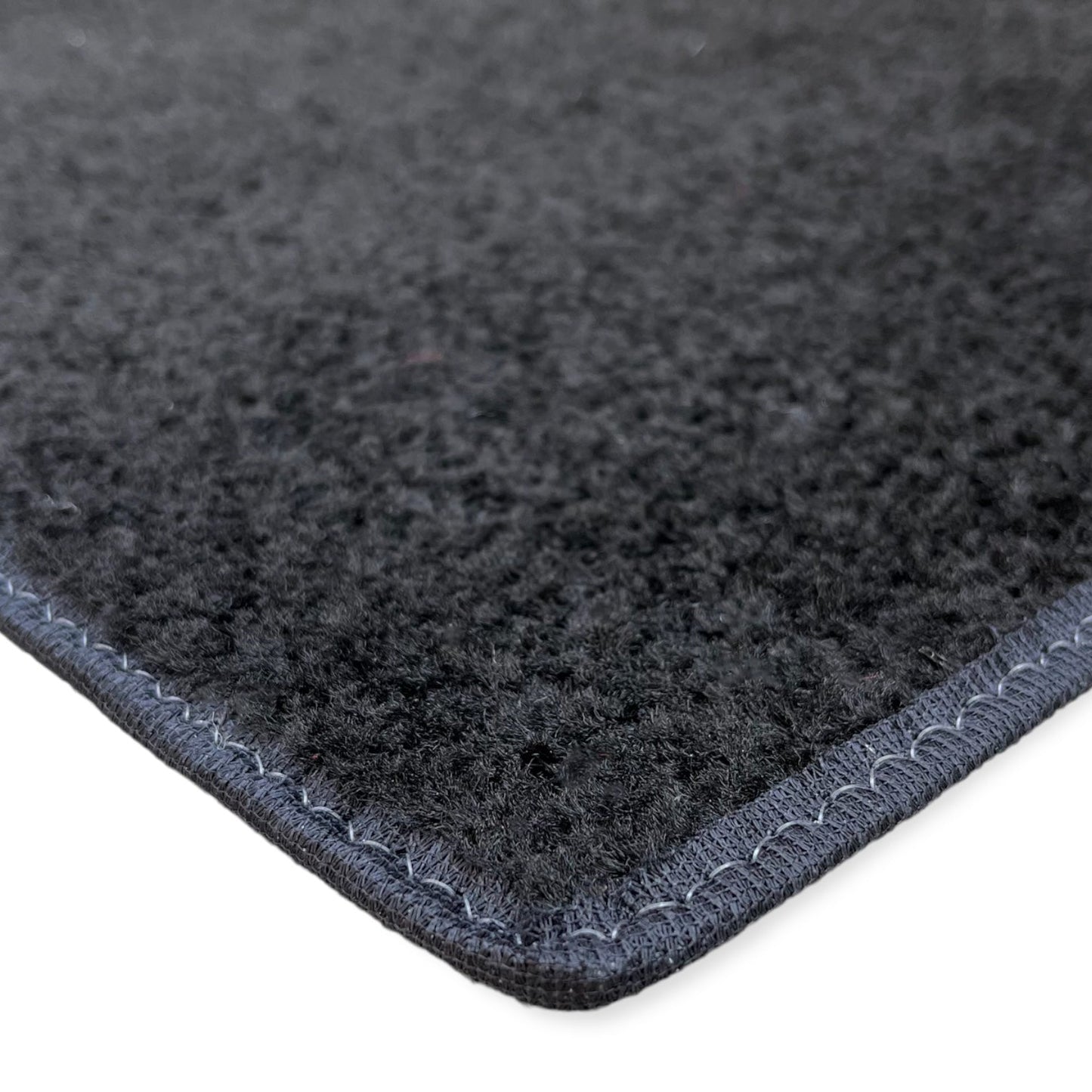 Black felt rug with stitched edges, soft texture, perfect for home decor and comfort.