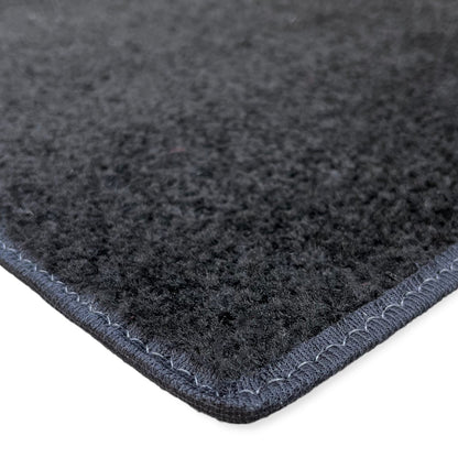 Black felt rug with stitched edges, soft texture, perfect for home decor and comfort.