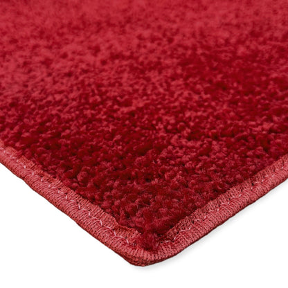 Plush red area rug with a soft texture and stitched edges, ideal for enhancing cozy interiors.