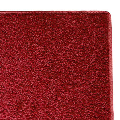 Deep red plush area rug made of soft, durable material for cozy home decor and comfort.