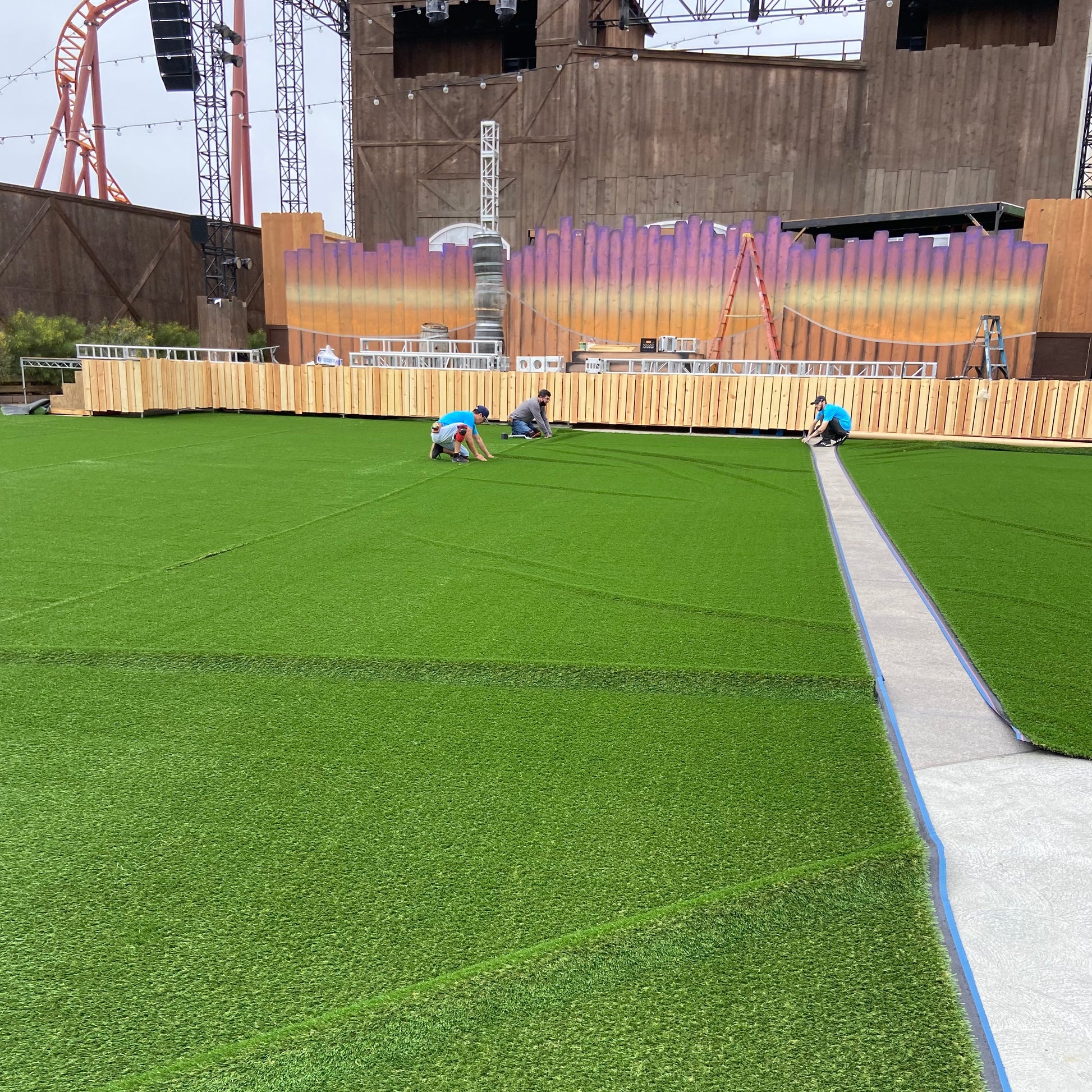 Artificial grass installation, vibrant green color, high-quality turf, suitable for outdoor events.