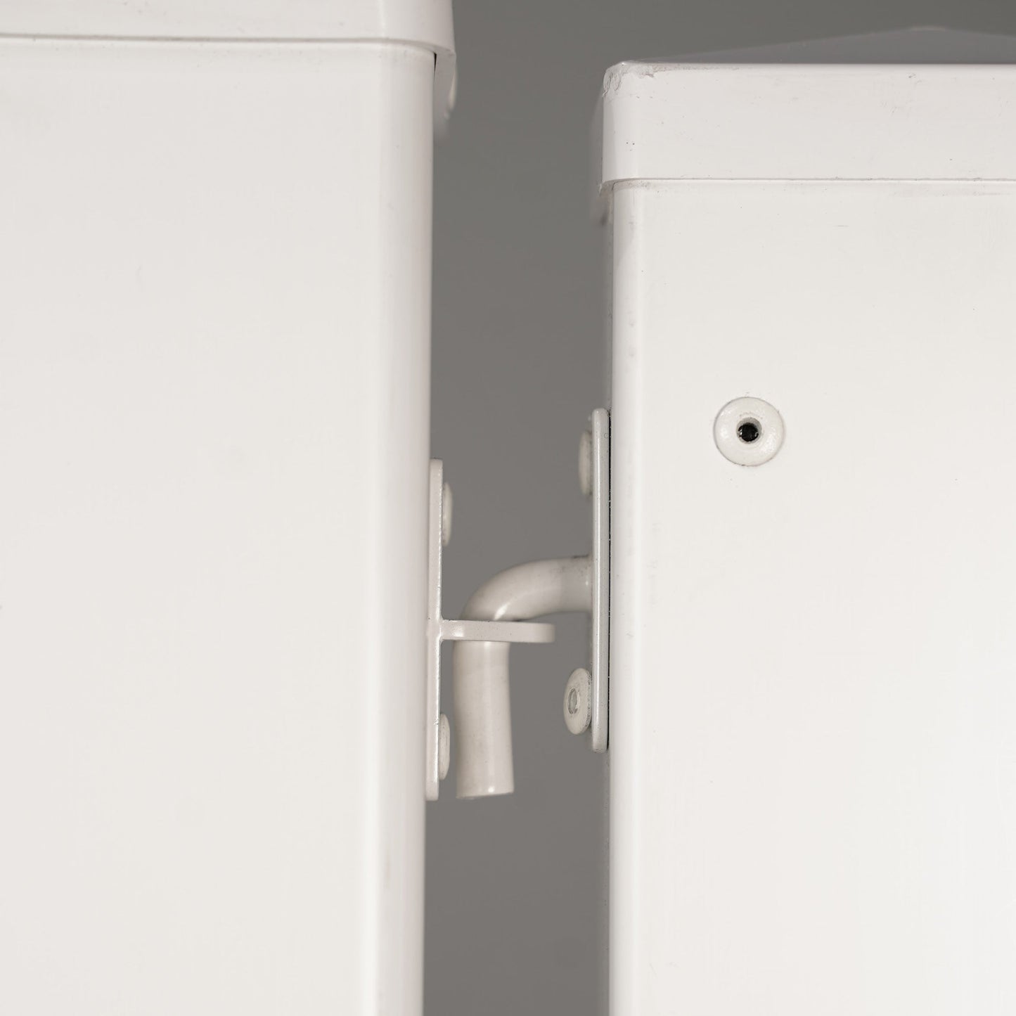 Close-up of white metal cabinet latch, highlighting durable design and smooth functionality.