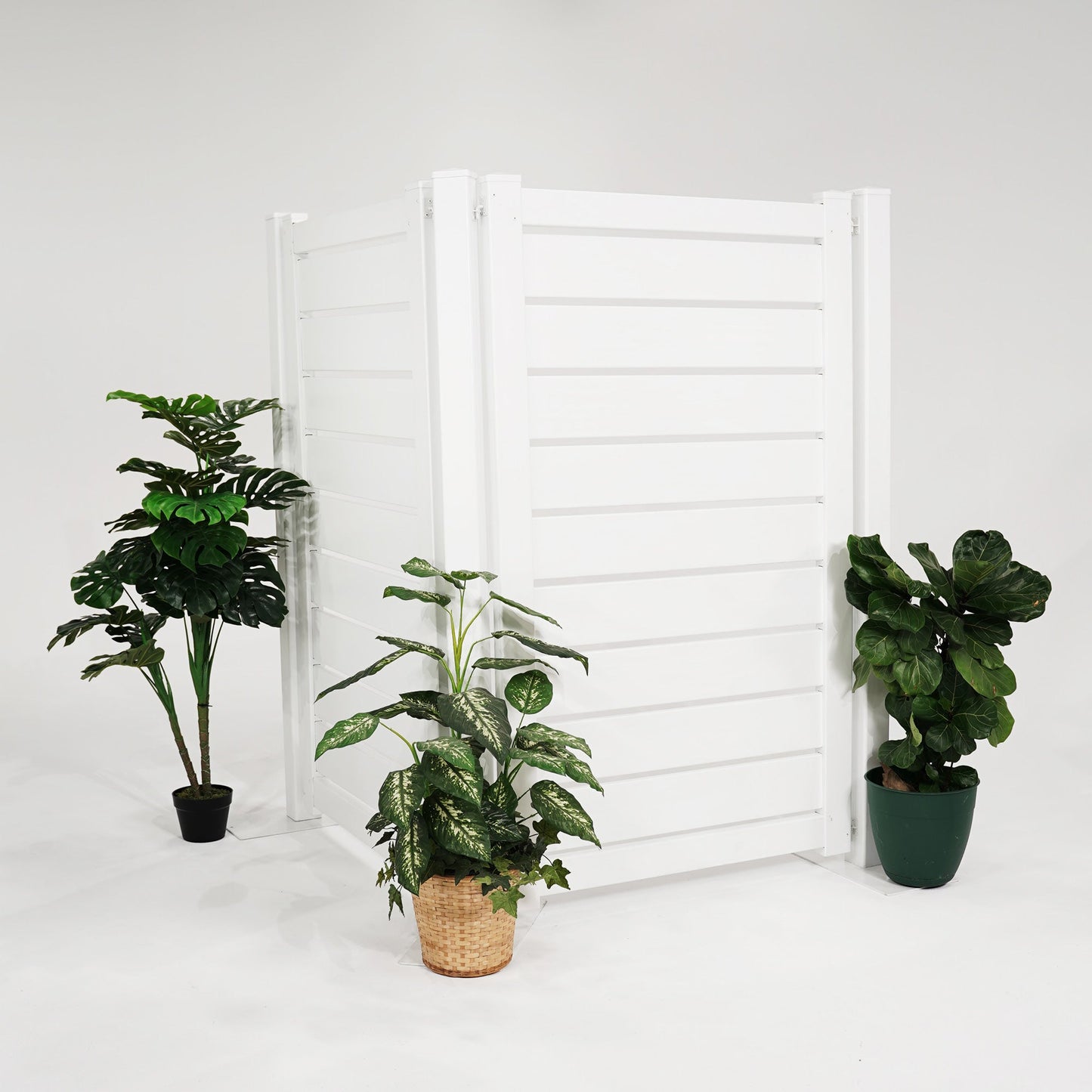 Modern white outdoor privacy screen with decorative plants on either side for a stylish garden setup.