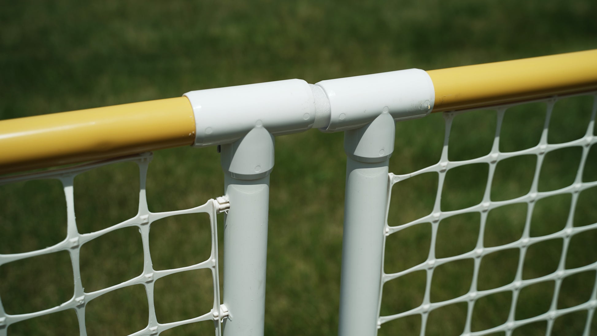 Close-up of a white and yellow sports net pole connector, ideal for outdoor games and recreational use.