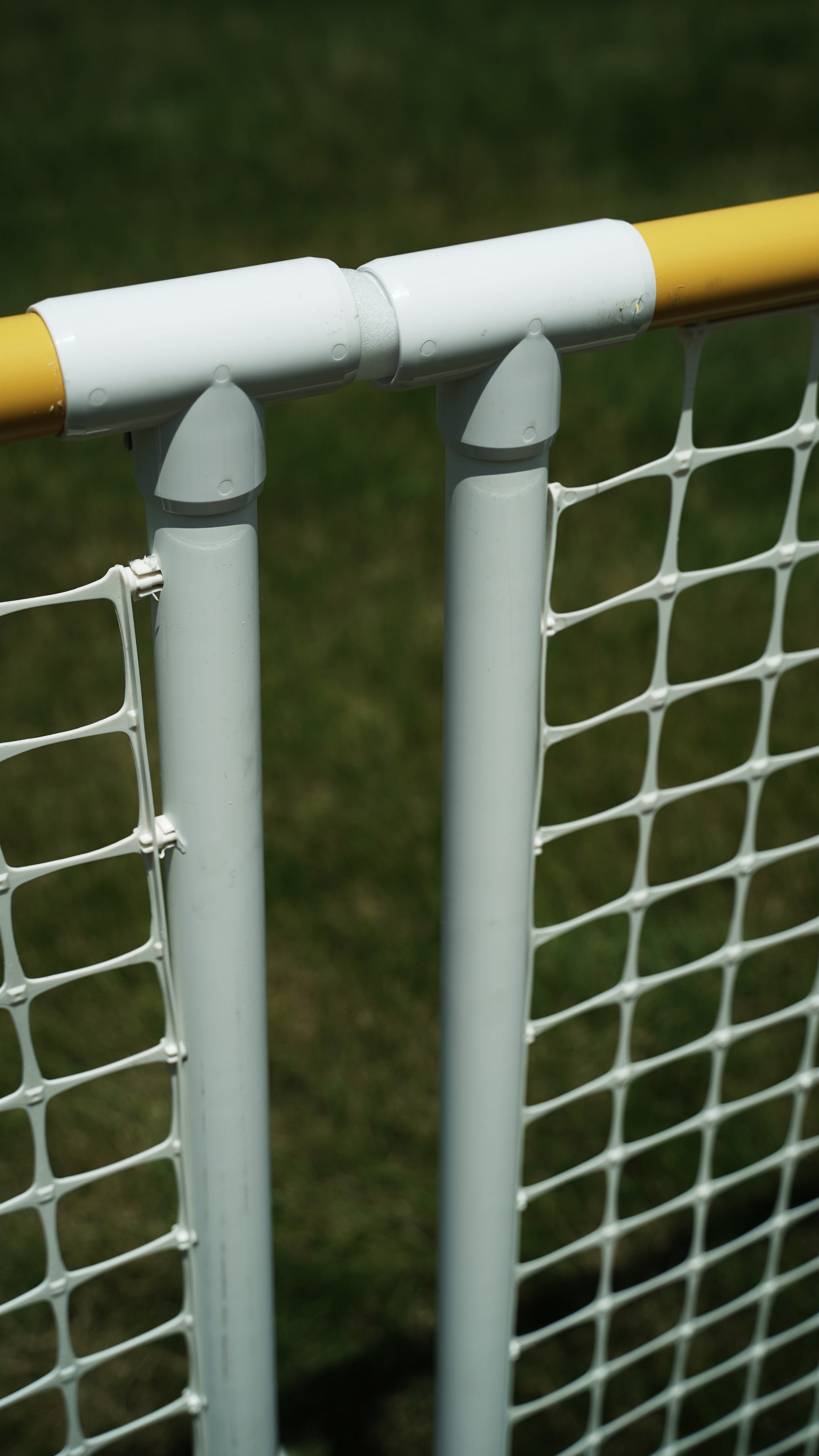 Durable white plastic netting poles with yellow top, ideal for sports or backyard use.